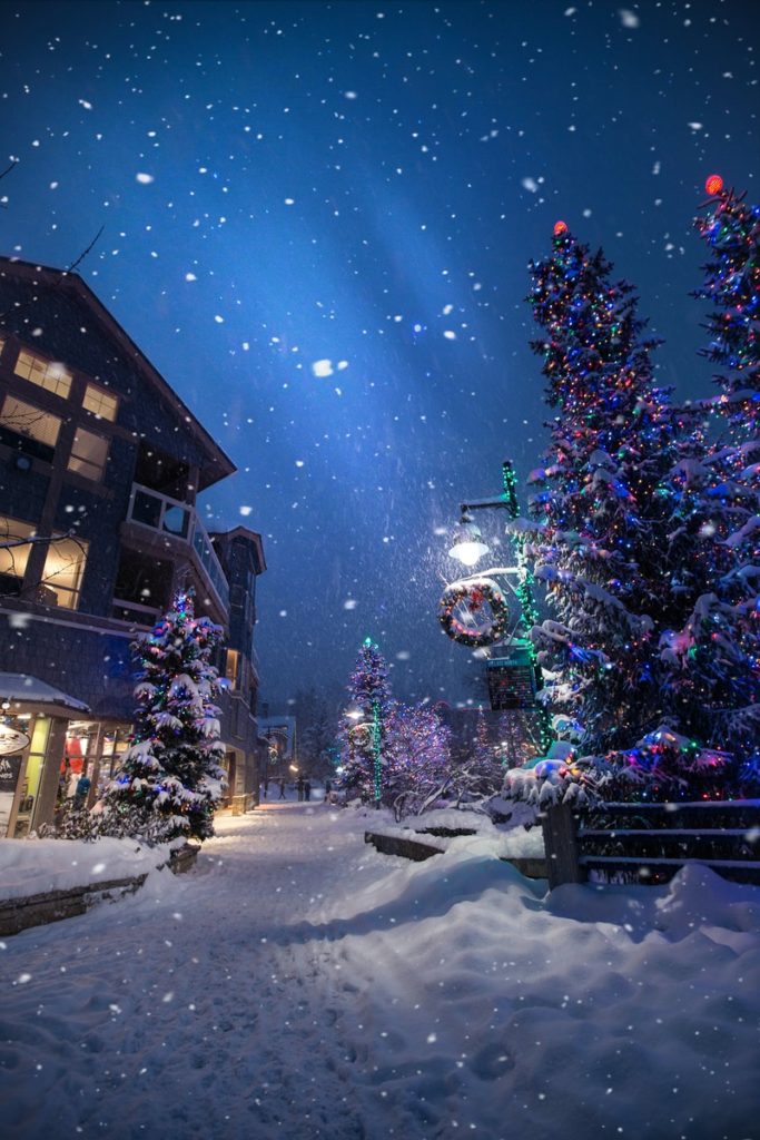 Snowy Christmas village at night. 8 Ideas to Add to Your Christmas Traditions with Family.