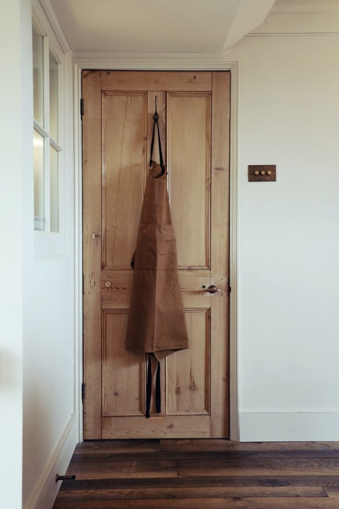 brown coat hanging on door