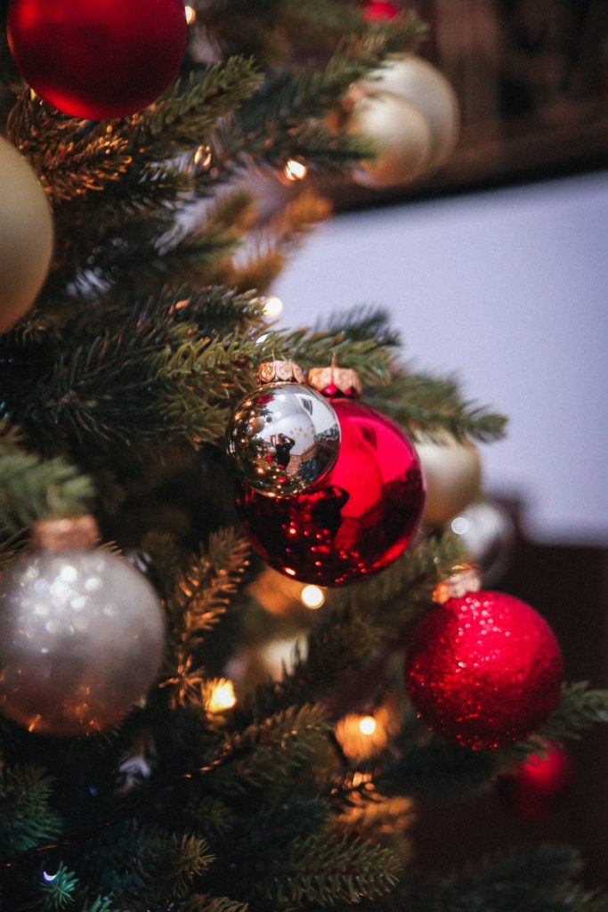Christmas tree branches with silver, gold and red bulbs on them. How to start your budget for Christmas 2022!